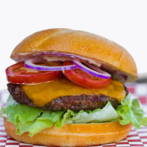Burger with Black angus beef, American cheese, mayonnaise, lettuce, tomato, red onion on a fresh kaiser roll
